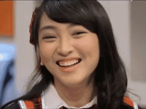 a close up of a woman 's face with a smile on it .