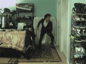 a man in a suit is dancing in a bedroom