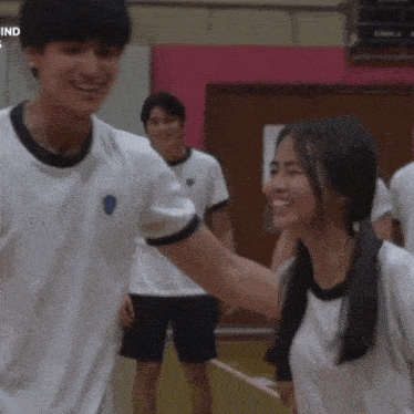 a boy and a girl are laughing together in a gym