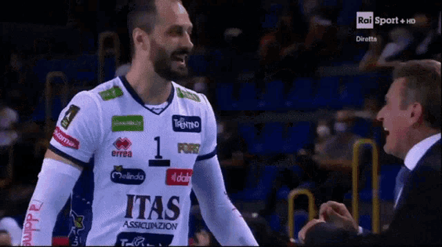 a man wearing a white and blue jersey that says itas