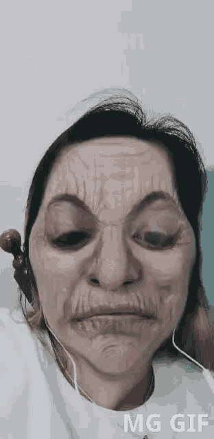 a woman is wearing headphones and making a funny face with a mask on her face .