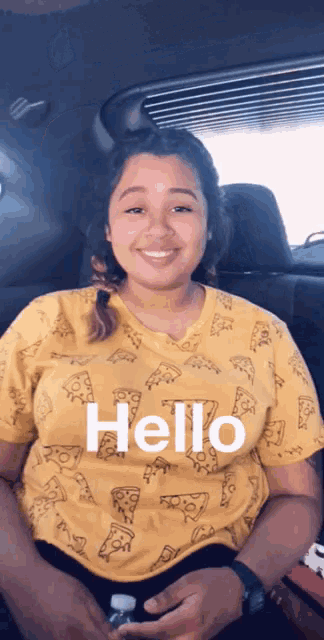 a girl in a yellow shirt with pizza slices on it says hello