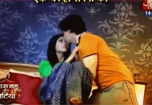 a man kissing a woman on a bed with a sign that says ' aabha '