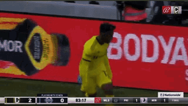 a soccer game is being played in front of a bodya advertisement