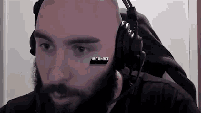 a bald man with a beard is wearing headphones and has the word une annonce above his head