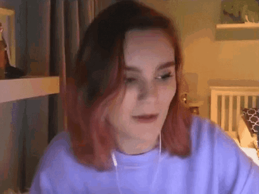 a woman with red hair is wearing headphones and a purple shirt