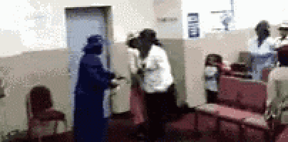 a group of people are standing in a room with chairs and a door .