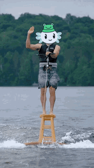 a man standing on a stool in the water with a frog on his head