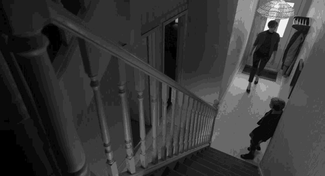 a woman walking down a set of stairs in a hallway