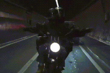 a person is riding a motorcycle in a dark tunnel .