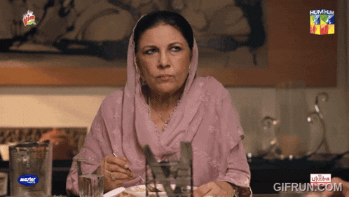 a woman sitting at a table with a hum hum logo on the corner