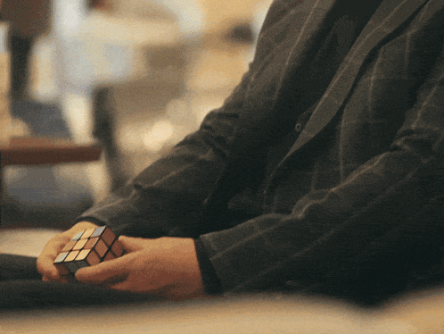 a man is holding a rubik 's cube in his hands