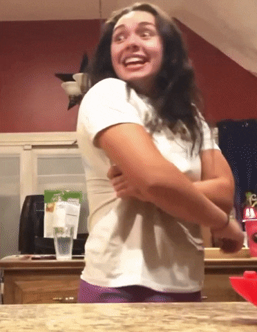 a woman in a white shirt is standing in front of a kitchen counter
