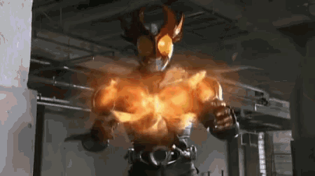 a man in a superhero costume is standing in a dark room with a fire coming out of his chest .