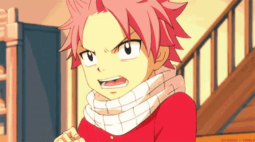 a young boy with pink hair is wearing a red shirt and a scarf .