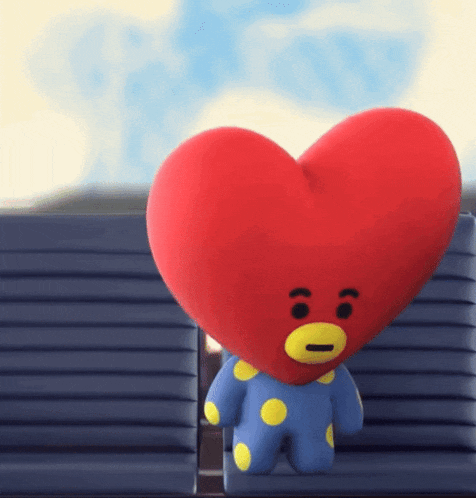 a stuffed animal with a red heart on its head and a yellow nose