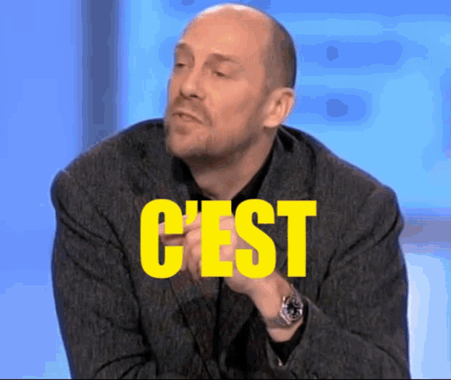 a bald man in a suit with the word c'est in yellow