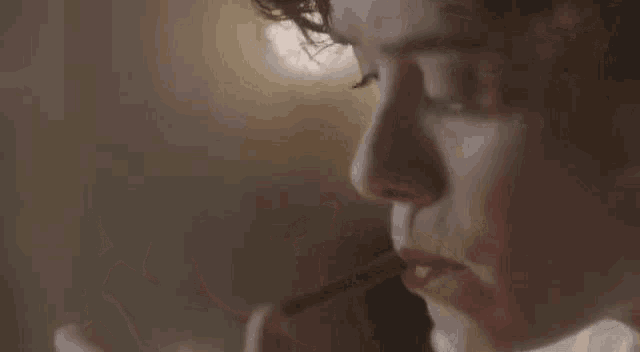 a woman is lighting a candle with a match in her mouth .