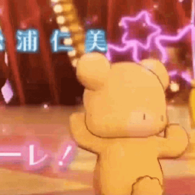 a teddy bear is dancing on a stage with chinese writing behind it .