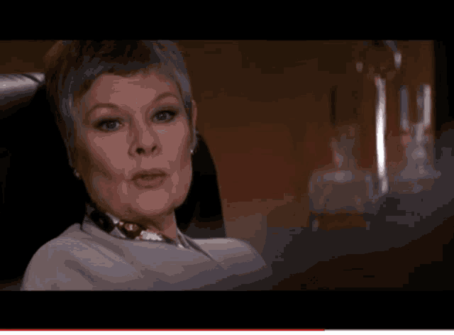 a woman is sitting in a chair and the word dinosaur is on the screen behind her