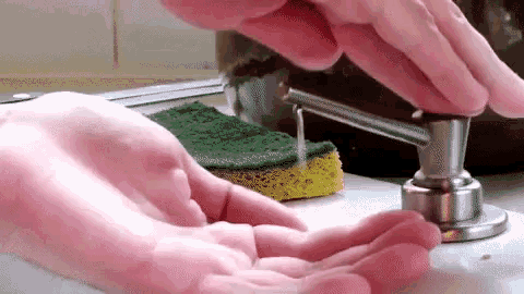 a person is using a soap dispenser to dispense liquid into their hand