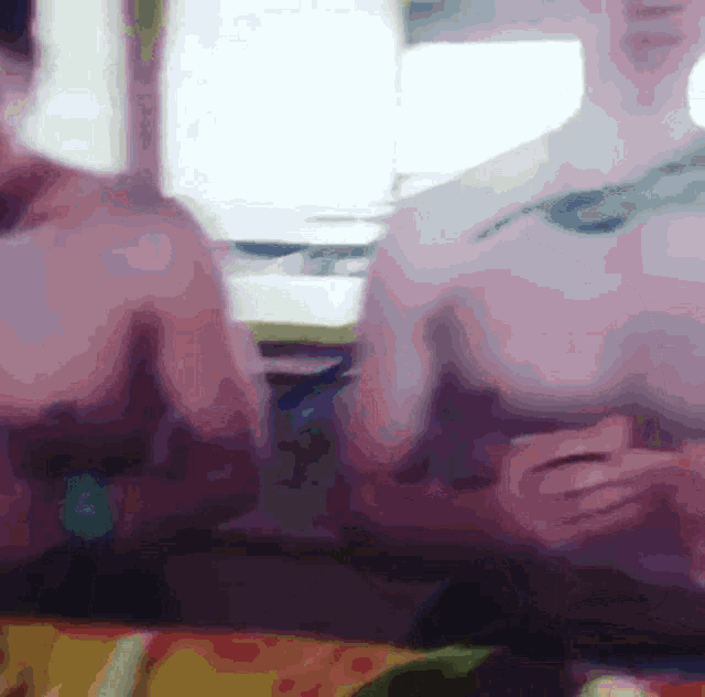 a blurred image of two people sitting at a table with their arms crossed