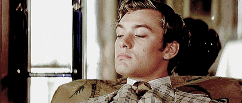 a man with his eyes closed is wearing a plaid tie