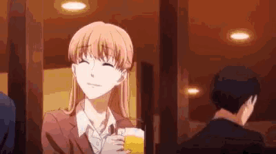 a woman is holding a glass of beer and smiling while sitting at a table .