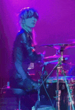 a woman with red hair is playing drums on stage