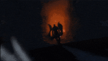 a silhouette of a person with a trident in a dark room