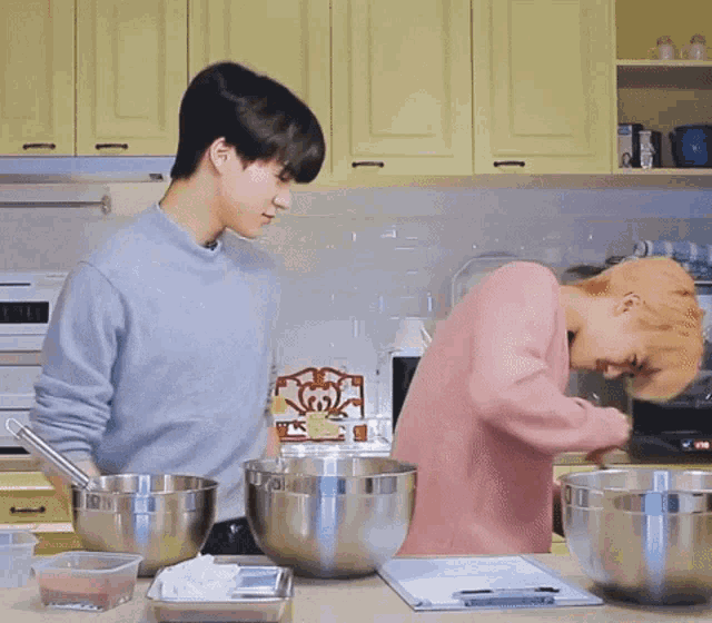 a man in a pink sweater is putting something in a bowl