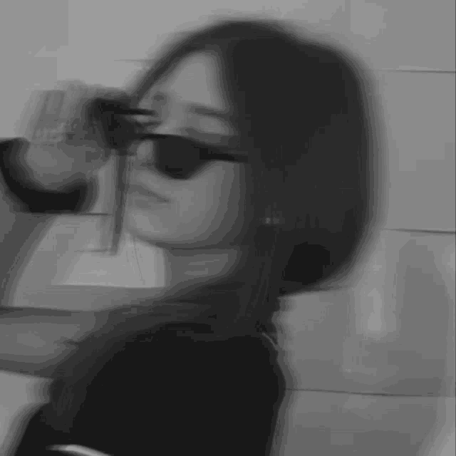 a blurry picture of a girl wearing sunglasses .
