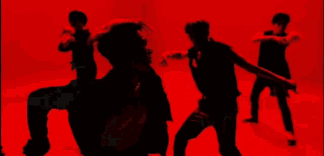 a group of men are dancing on a red floor .