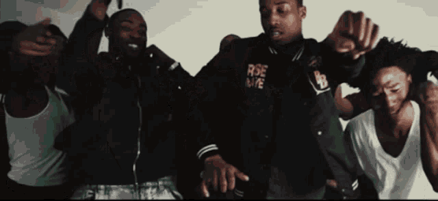 a group of men are dancing and one of them is wearing a jacket that says rise love