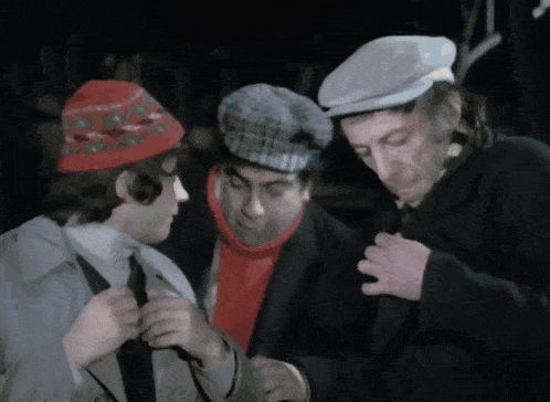 three men wearing hats and scarves are standing together