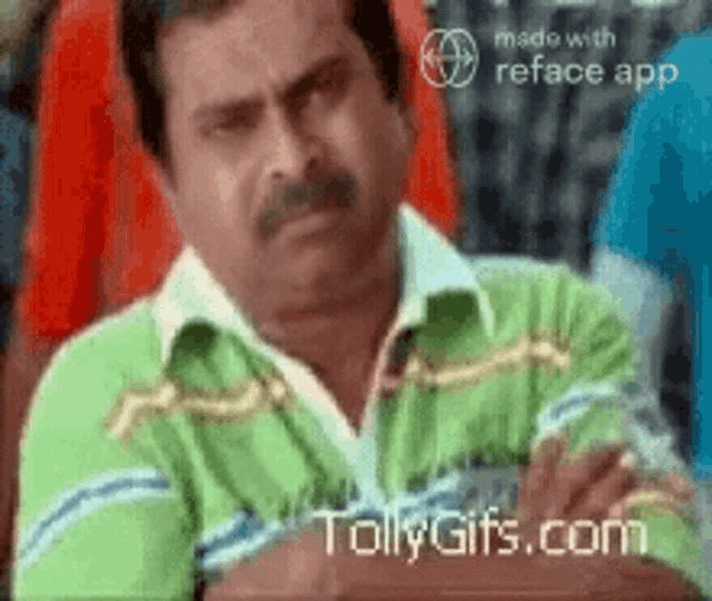 a man in a green shirt is sitting with his arms crossed ..