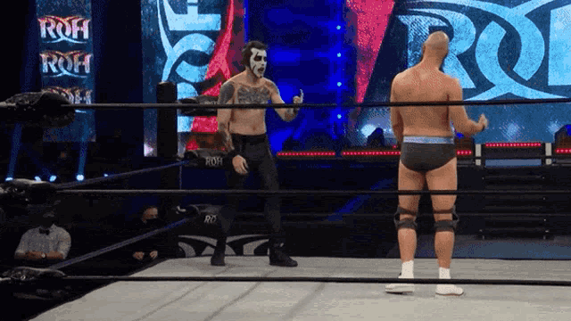 two wrestlers are standing in a ring with the word roh in the background
