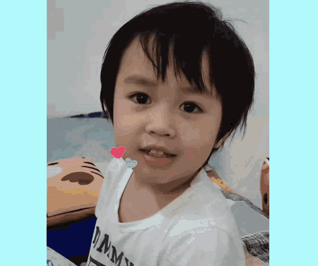 a young boy wearing a white shirt that says tommy