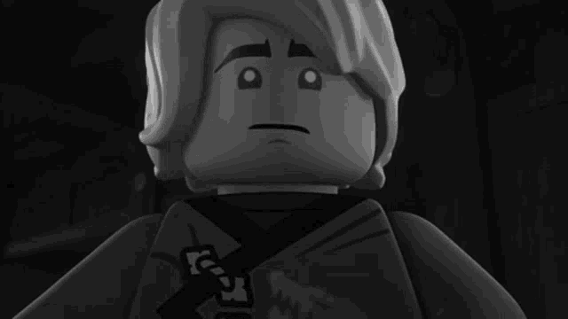 a black and white image of a lego figure with a sad look on his face