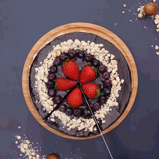 a chocolate cake with blueberries and strawberries on top