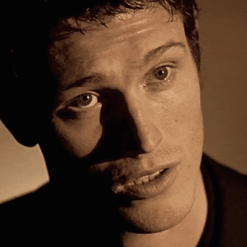 a close up of a man 's face with a shadow on his face