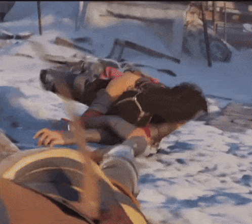 a man is laying on the ground in the snow while another man stands behind him