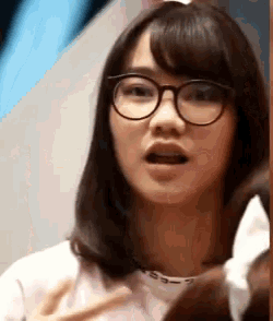 a woman wearing glasses is making a funny face .