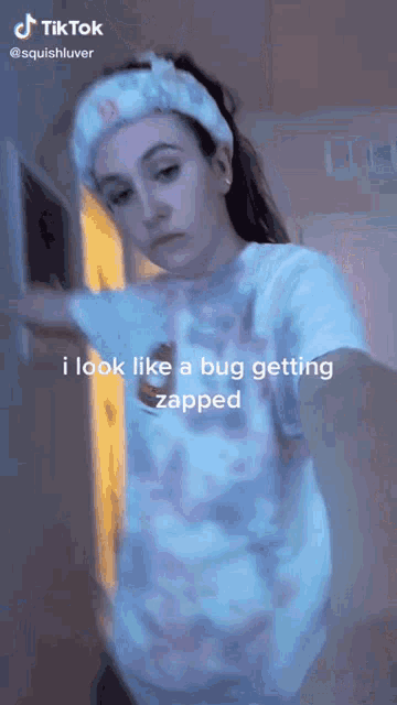 a woman is taking a selfie with a caption that says i look like a bug getting zapped