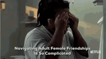 a man is covering his face with his hands and the words `` navigating adult female friendships is so complicated '' are above him .