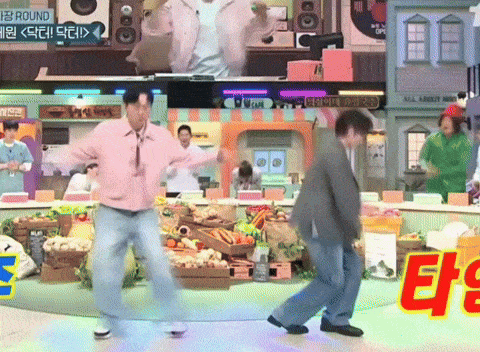 two men are dancing in front of a sign that says " round "