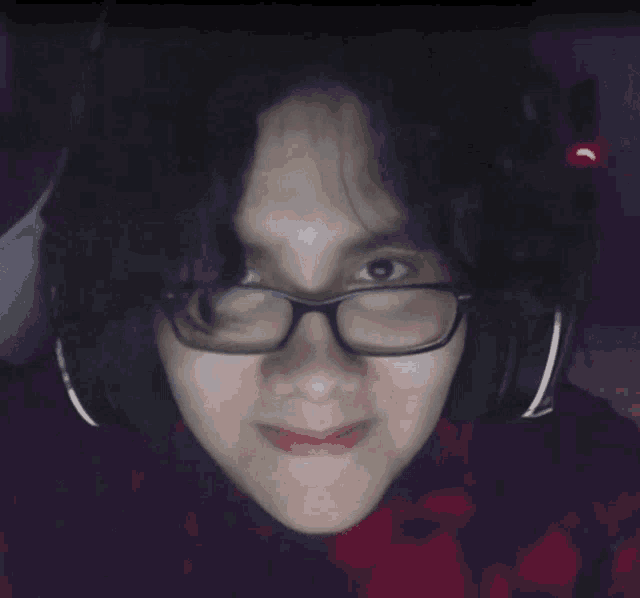 a woman wearing glasses and headphones is smiling