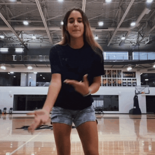 a girl is dancing in a gym with a sign that says auburn