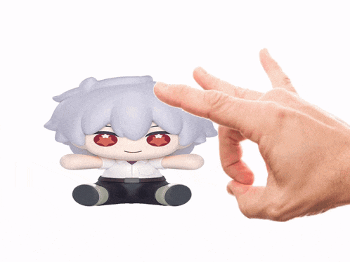 a person is holding a stuffed toy with a red star on its eyes