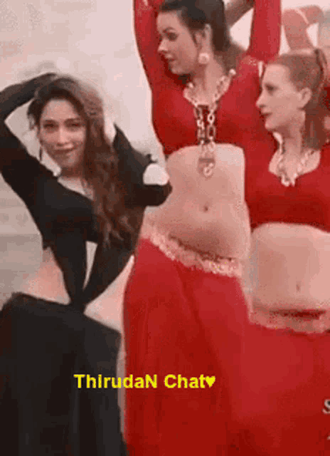 a group of women are dancing together in red and black clothes .